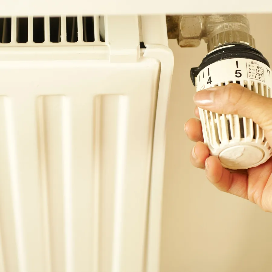 Hand turning a thermostatic radiator valve